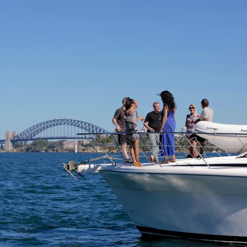 Guests on deck aboard Platinum Cruises with Sydney Harbour Bridge in the background